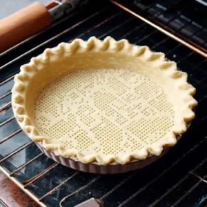 Fond de tarte en cuisson à blanc avec plombs de cuisson et papier sulfurisé au four