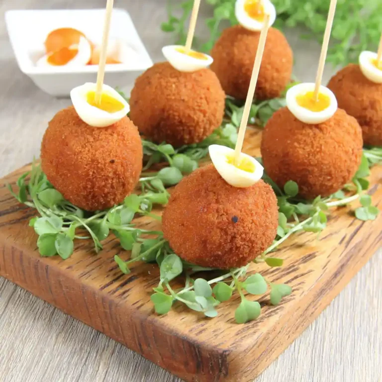 Mini croquettes de crabe dorées aux œufs de caille sur planche en bois avec micro-pousses et huile d'olive