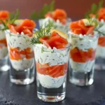 Verrines de saumon fumé élégantes avec ricotta et herbes fraîches sur plateau en bois