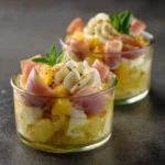 Verrines sucré-salé avec pomme, chèvre et jambon fumé disposées élégamment sur plateau d'ardoise