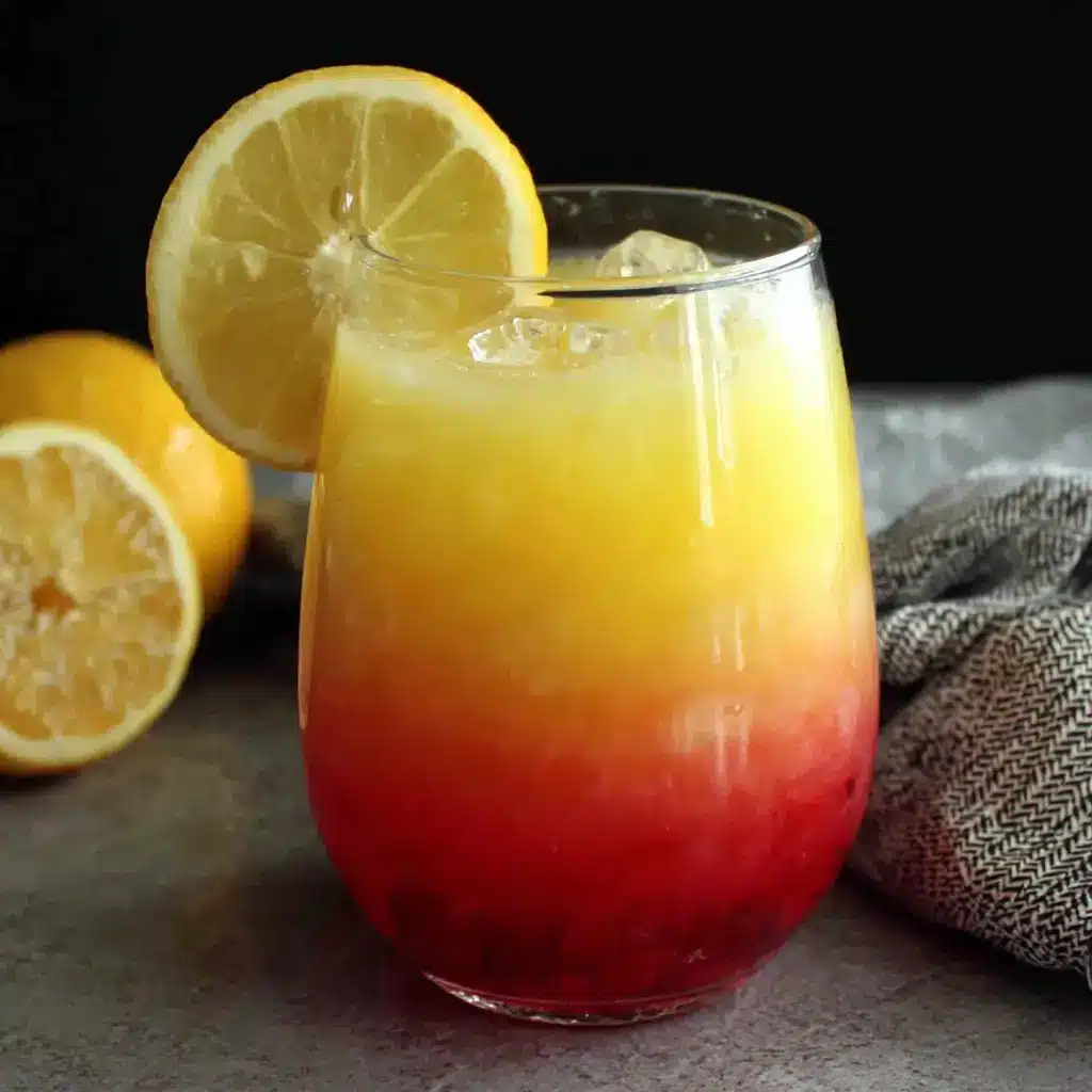 Cocktail Rio avec dégradé orange-rouge imitant un coucher de soleil dans un verre hurricane