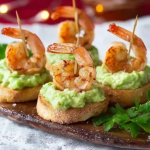 Toast aux crevettes et guacamole sur une planche en bois, garni d'un cure-dent, prêt à être servi en apéritif