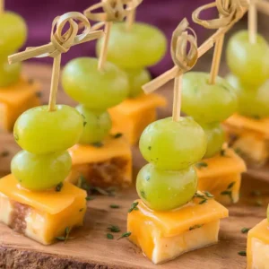Brochettes apéritives mimolette-raisin disposées sur plateau