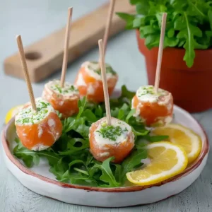 Sucettes de saumon au fromage frais sur assiette avec roquette et citron pour apéritif