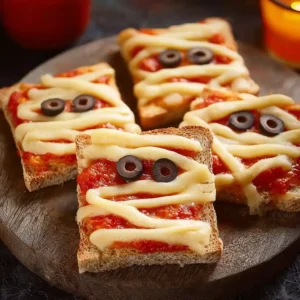 Recette toasts d'Halloween momies au fromage fondant avec sauce tomate et olives noires
