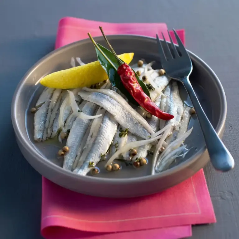anchois marinés​ au vin blanc dans une terrine, nappés d'huile d'olive et de thym