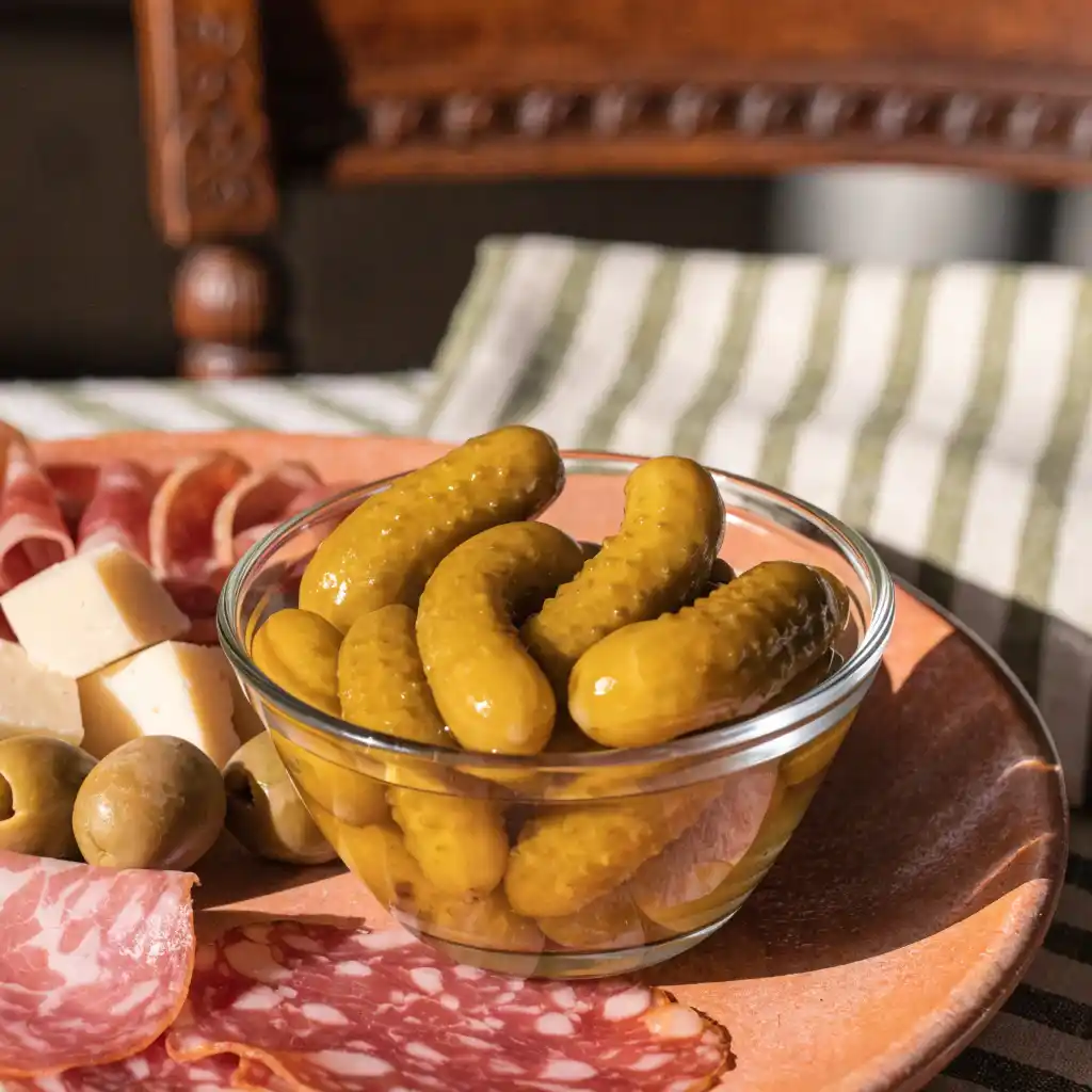Cornichon au vinaigre servi à l'apéritif avec charcuterie et fromage