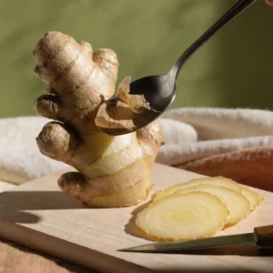 Étape 1 de la gingembre boisson : gingembre frais pelé et émincé en fines lamelles sur une planche