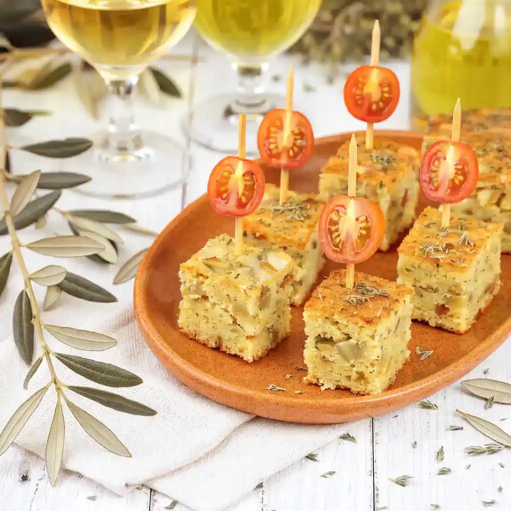 Cubes de cake tomate mozzarella piqués sur des pics apéritifs avec des tomates cerises